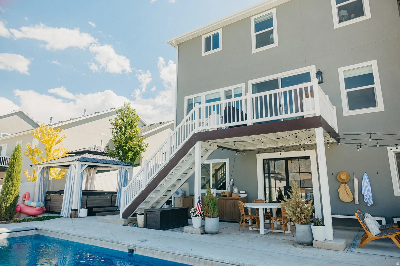 Exterior with a second-story deck, ground-level patio, private pool, and covered gazebo