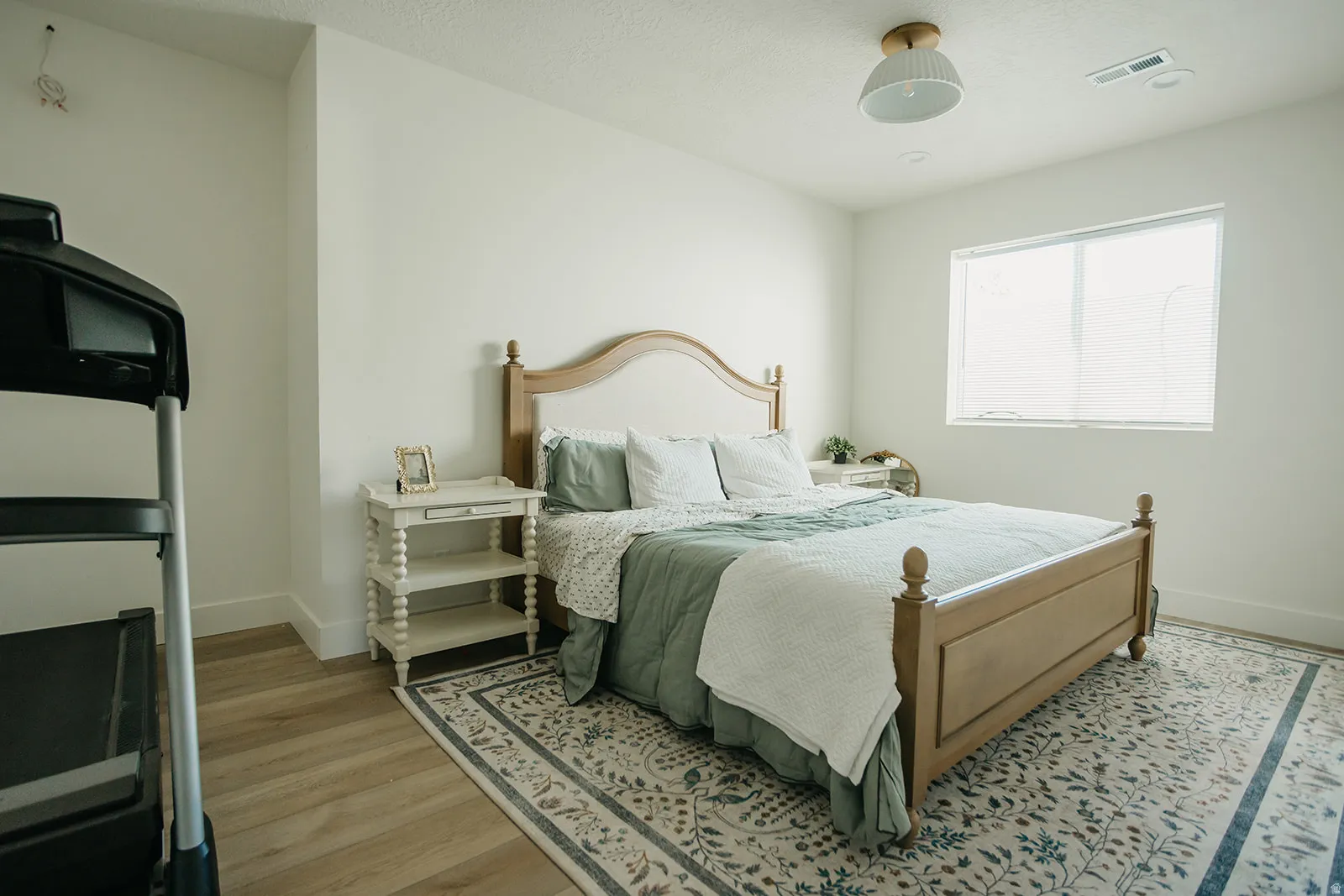 Light-toned wood-finish flooring, recessed window, and flush-mount ceiling light