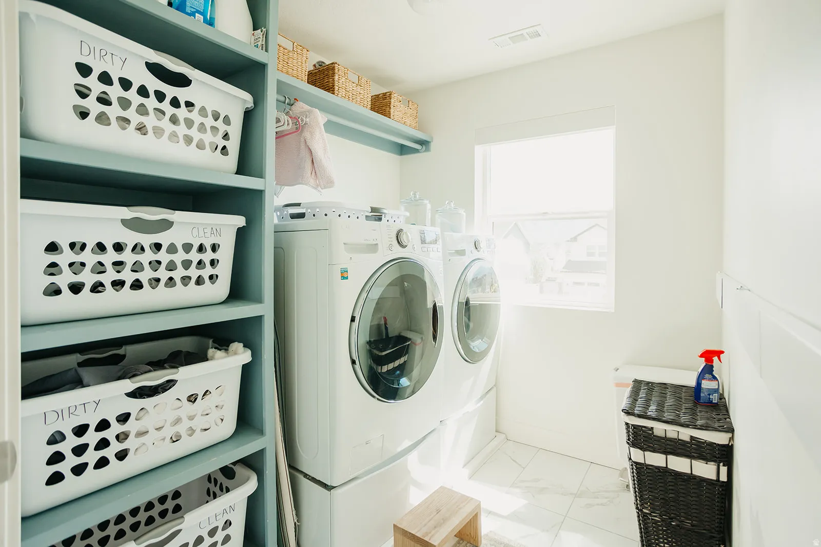 Laundry area featuring built-in shelving, a full-size window, and tile flooring