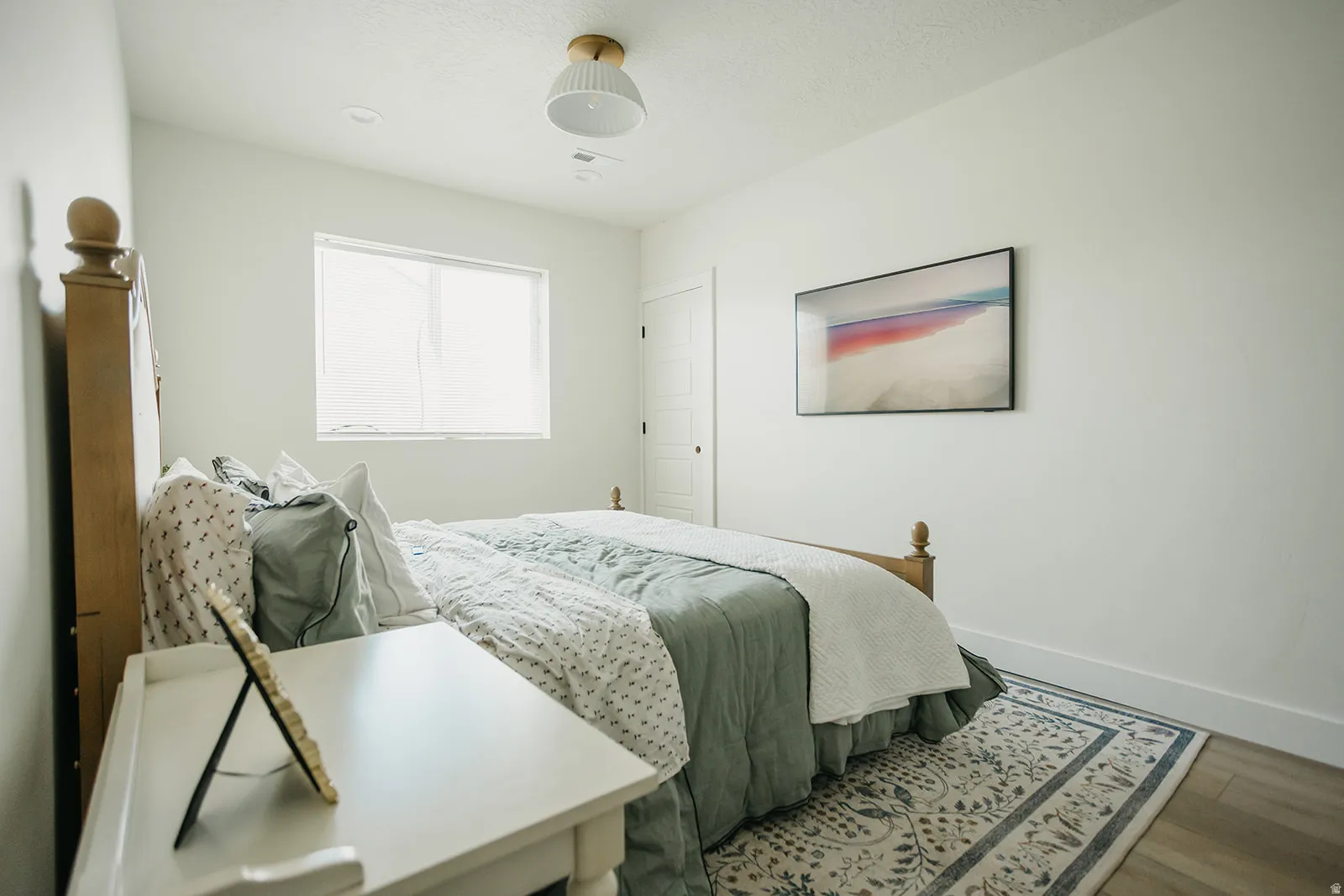 Recessed window with white trim, wood-finish flooring, and white interior doors