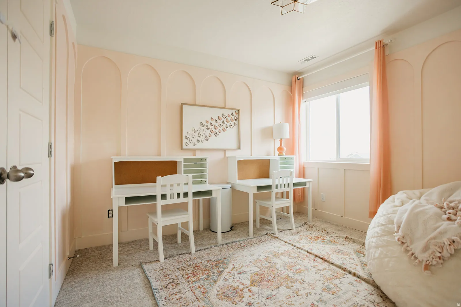 Arch wall paneling, dual workstations, and a large window with natural light