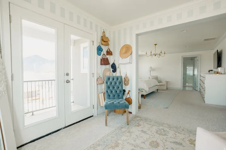 Double French doors with a balcony railing, striped wall paneling, and crown molding