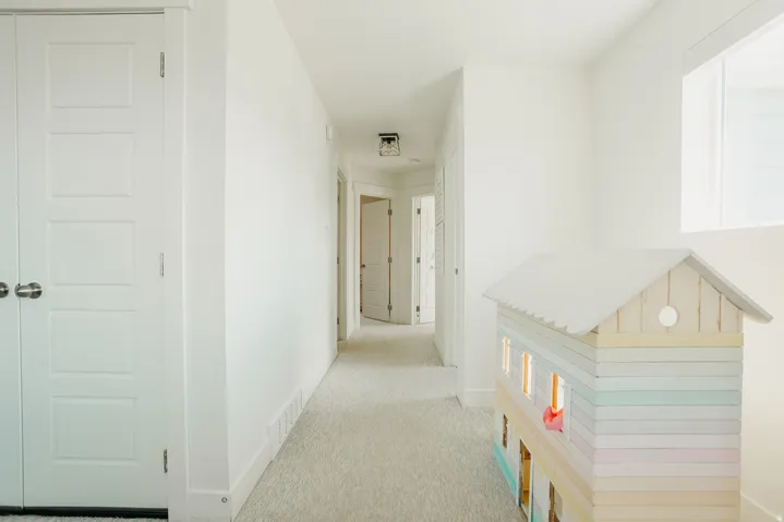 Crisp white walls, light-toned carpeting, recessed lighting, and white paneled doors