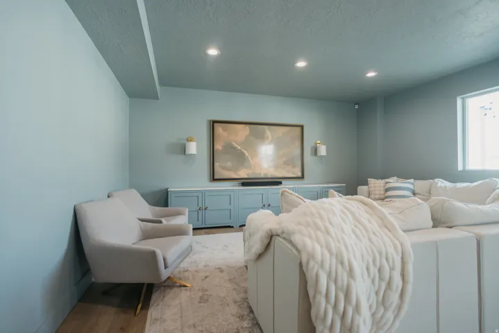 Recessed lighting illuminates a built-in media console with storage cabinetry