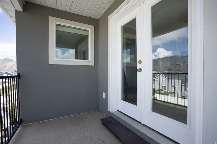 Exterior balcony featuring a concrete surface and black metal railing