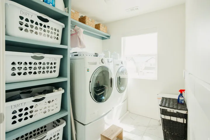 Laundry area featuring built-in shelving, a full-size window, and tile flooring