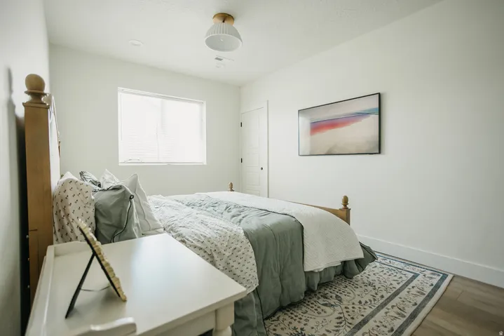 Recessed window with white trim, wood-finish flooring, and white interior doors