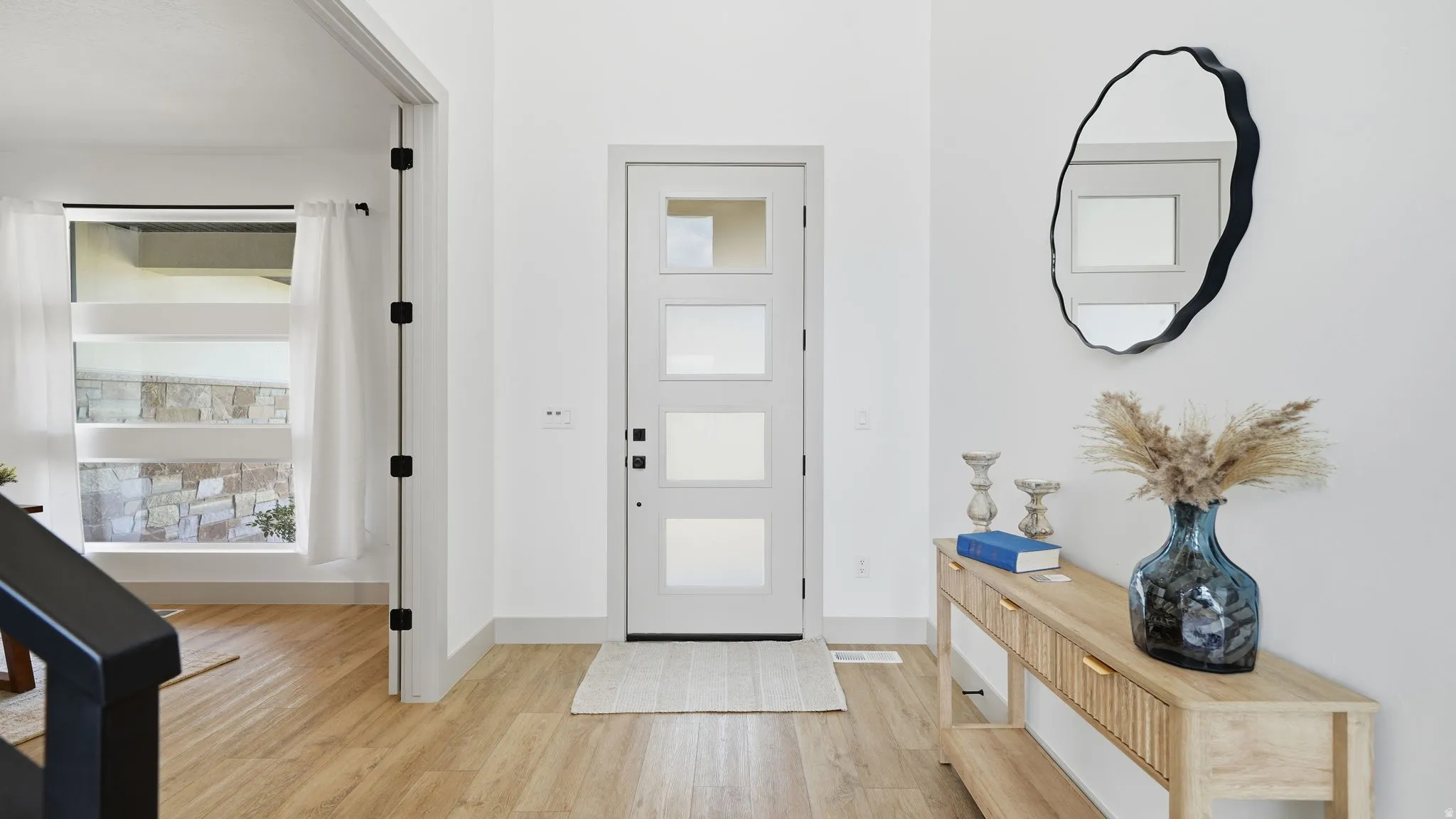 Entryway featuring a contemporary front door with privacy glass, wood-finish flooring, and white painted walls