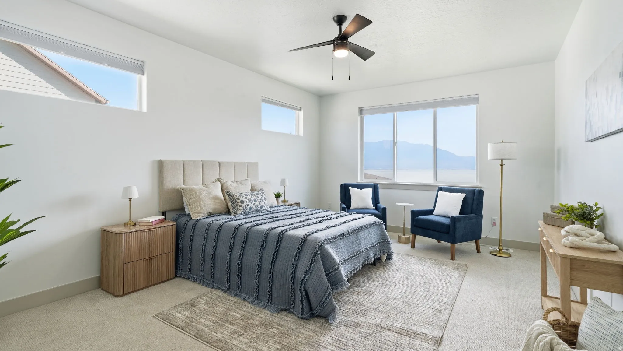 Room with expansive windows, a ceiling fan, and light-toned carpet flooring