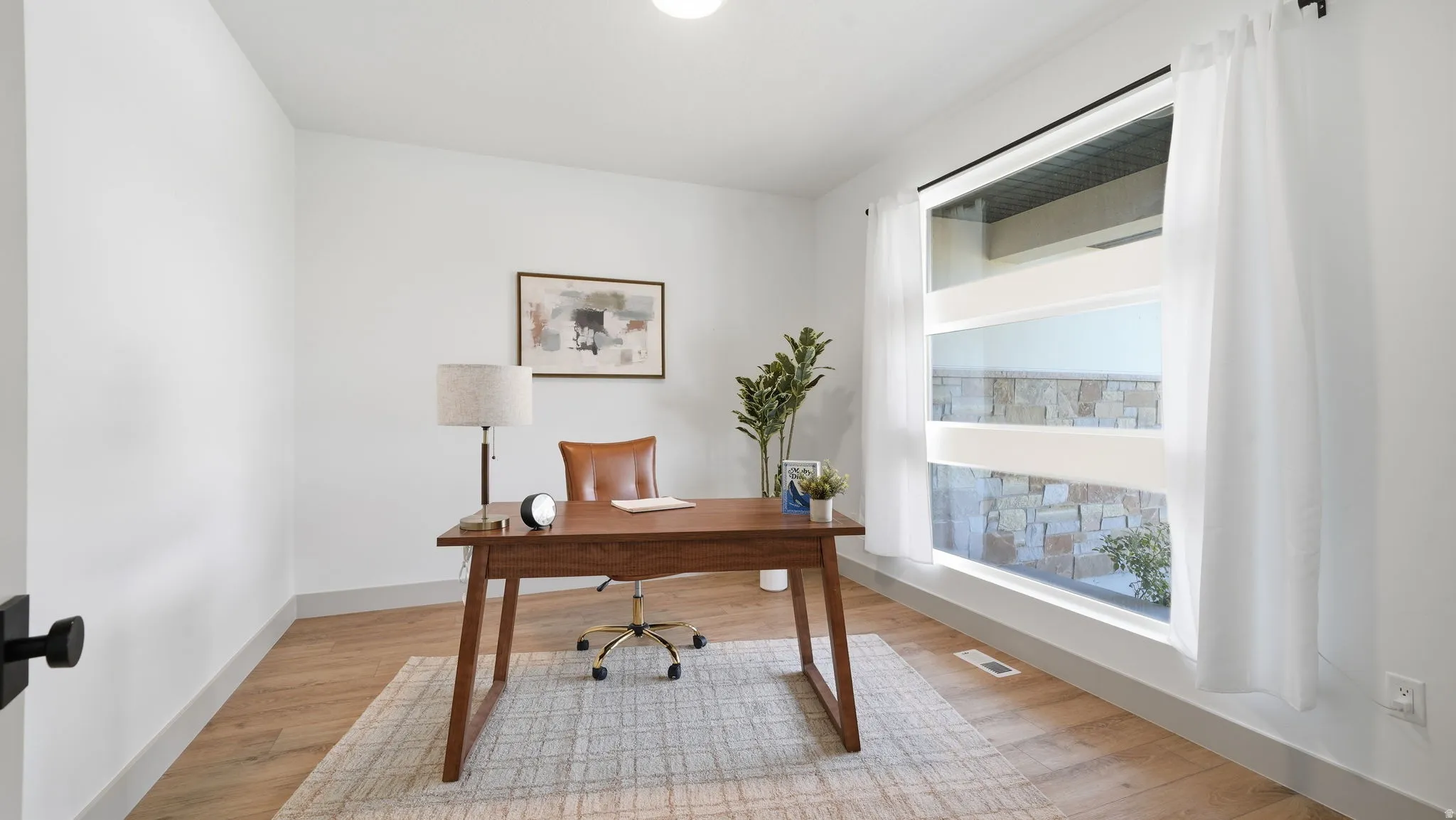 Wood-finish flooring, white walls, and a large window with white trim