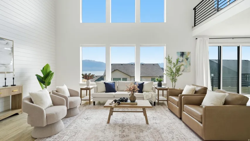 Vaulted ceilings with large windows, shiplap accent wall, and a multi-pane sliding glass door