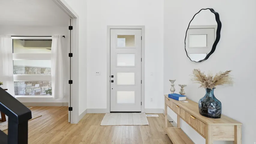 Entryway featuring a contemporary front door with privacy glass, wood-finish flooring, and white painted walls