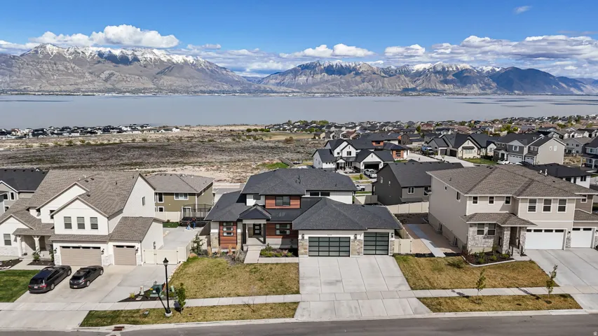 Modern residential architecture with a neutral color palette, featuring a multi-car garage, and a concrete driveway
