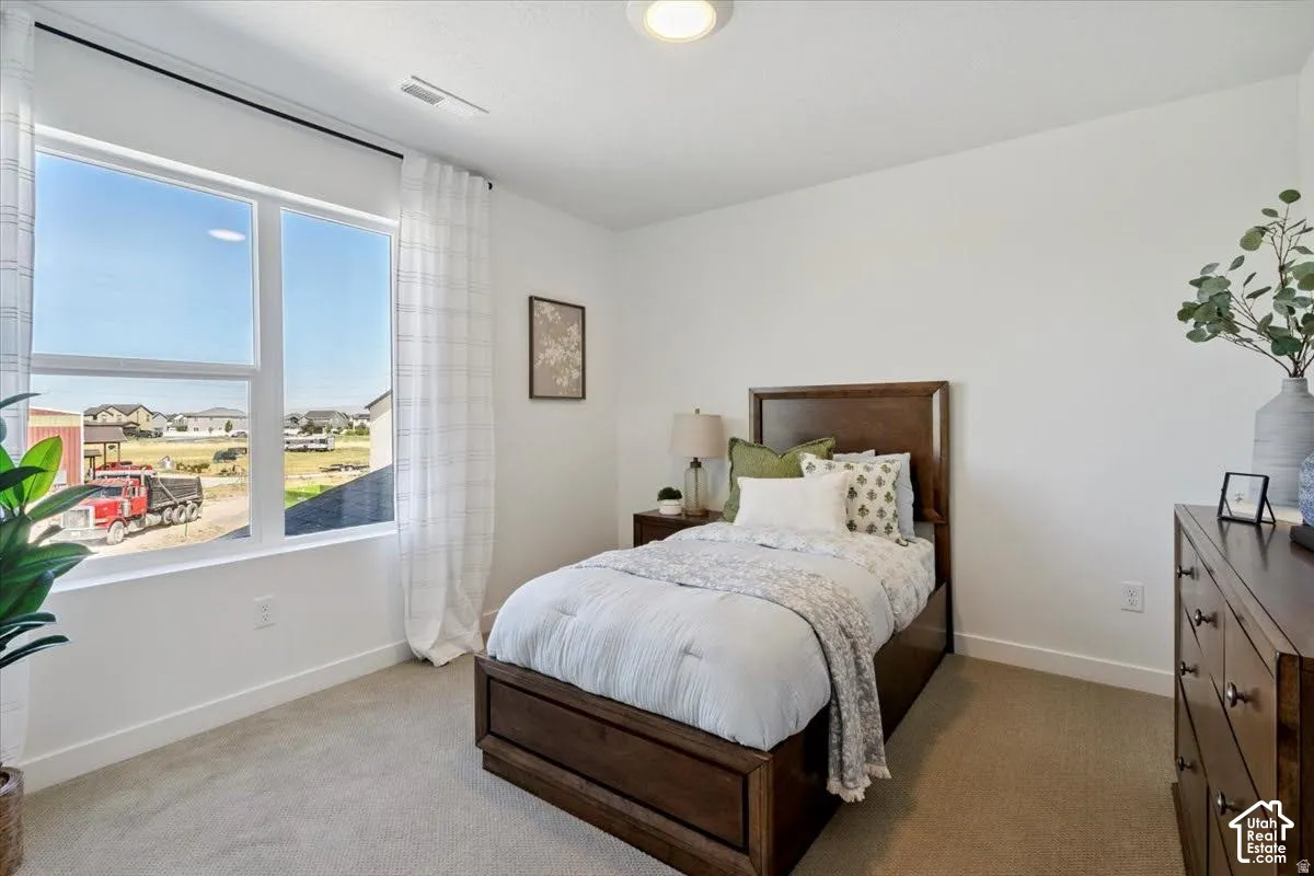 Recessed ceiling lighting, large window with ample natural light, neutral carpeting, and a built-in closet door