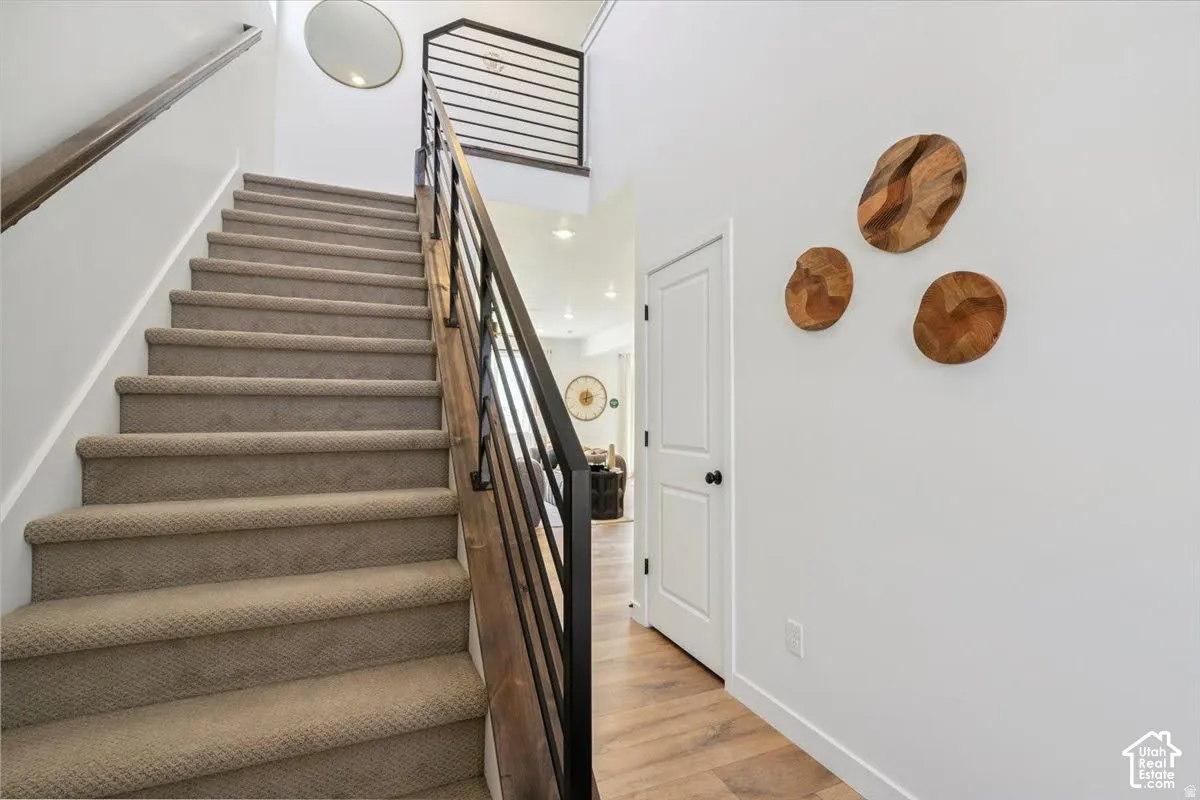 Carpeted staircase with dark wood-finish handrail and black metal balusters