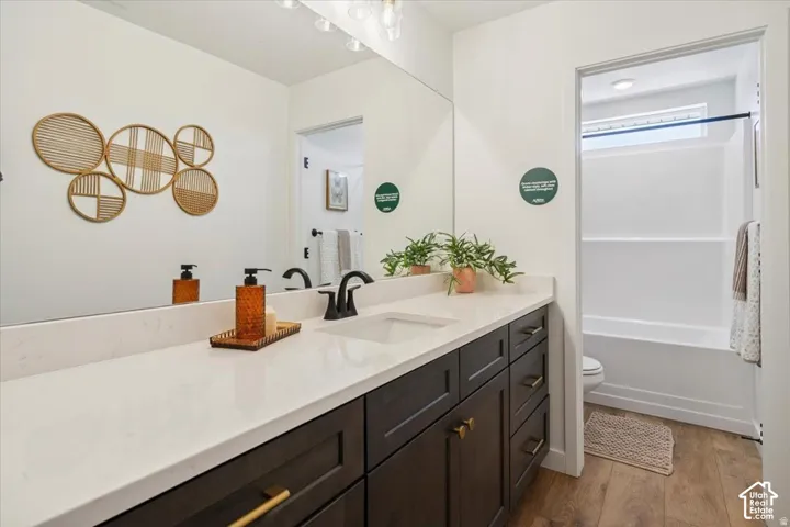 Spacious vanity with a white countertop, dark wood-finish cabinetry, and an integrated rectangular sink