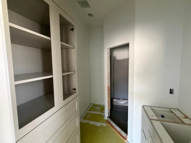 Built-in cabinetry with glass-front upper doors, multiple shelves, and integrated drawers