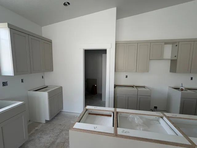Grey shaker-style cabinetry with upper and lower installations, a kitchen island base, and a white interior wall finish