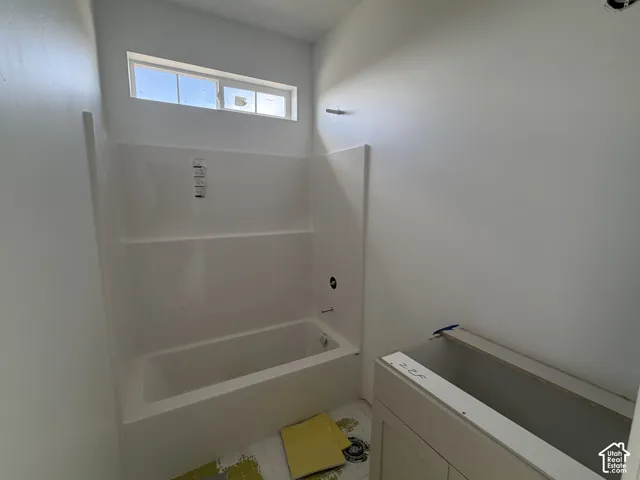 White acrylic tub and shower combination with a transom window