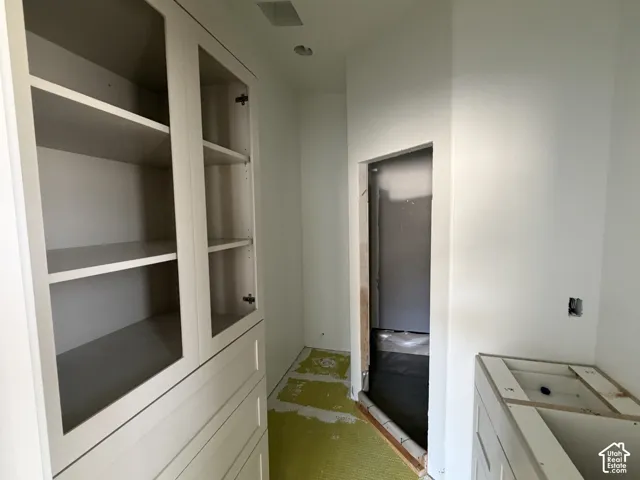 Built-in cabinetry with glass-front upper doors, multiple shelves, and integrated drawers