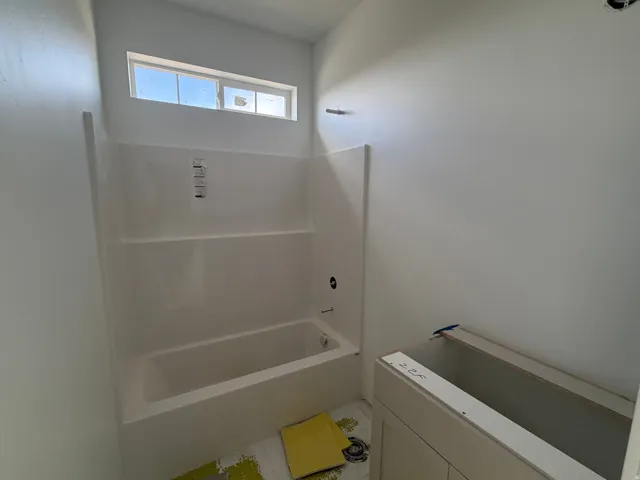 White acrylic tub and shower combination with a transom window