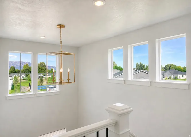 Bright interior with multiple windows, recessed lighting, and a contemporary gold-finish chandelier