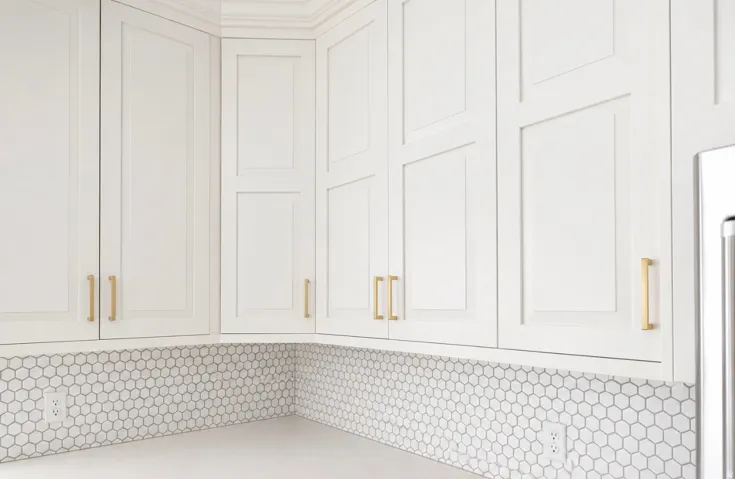 White shaker-style cabinetry with gold-tone hardware