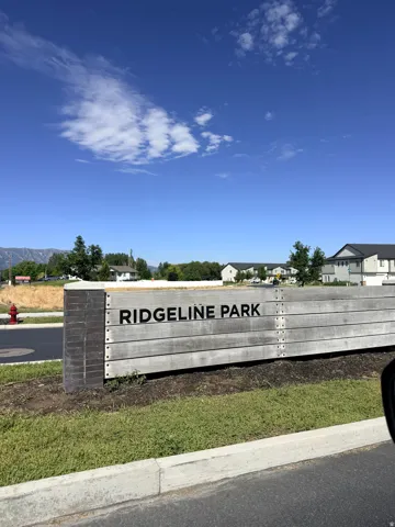 Community entrance sign featuring horizontal wood-finish planks and dark-toned accent panels