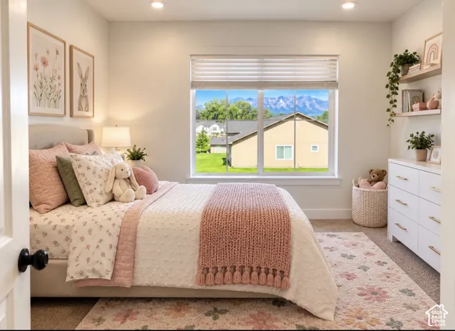 Bedroom 3: Bright secondary bedroom featuring large picture window with natural light, white built-in shelving with decorative planters, white dresser with drawer storage, wood-finish flooring, and coordinating area rug