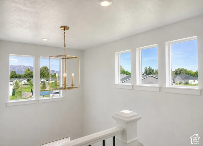 Bright interior with multiple windows, recessed lighting, and a contemporary gold-finish chandelier