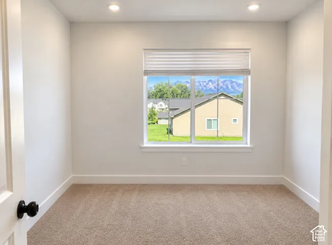 Bedroom 2 & 3: Neutral-toned interior room featuring wall-to-wall carpeting, recessed ceiling lighting, and a window with mountain scenery
