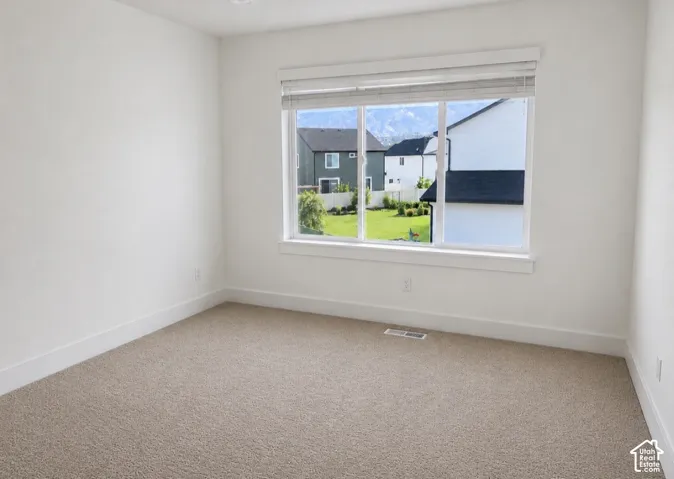 Bedroom 4: Neutral-toned carpeting, crisp white walls, large triple-pane window with horizontal blinds, and mountain backdrop