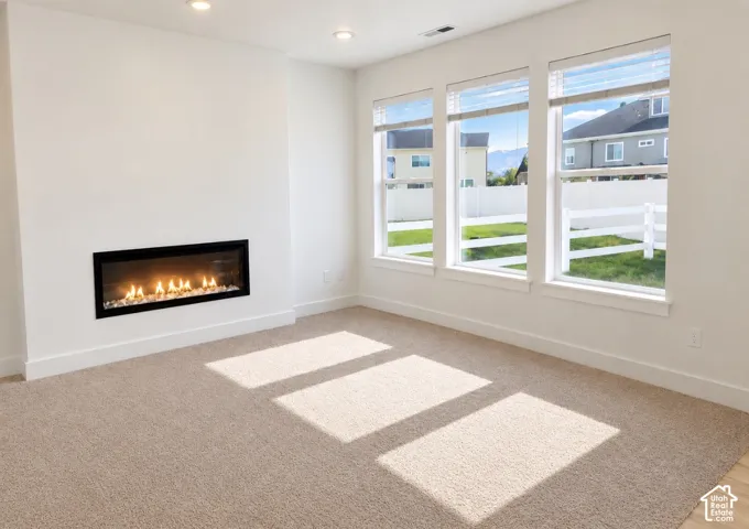 Linear wall-mounted fireplace, wall-to-wall carpeting, and triple windows with horizontal blinds