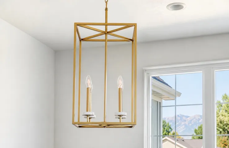 Gold-tone geometric chandelier with candle-style lights, recessed ceiling lighting, and a white-framed window