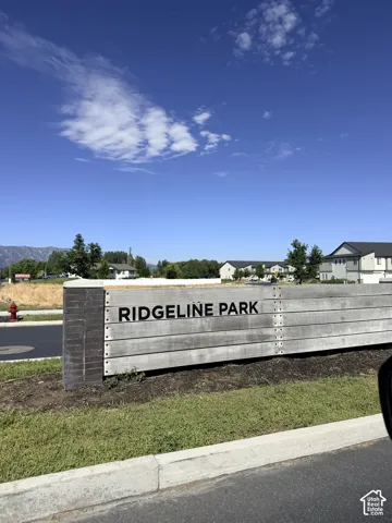 Community entrance sign featuring horizontal wood-finish planks and dark-toned accent panels