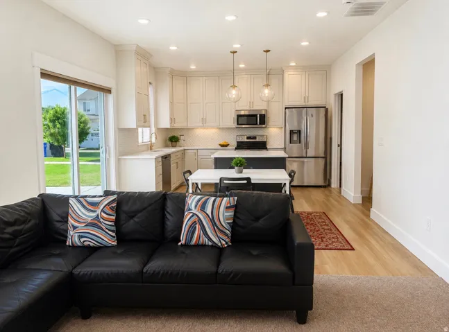 Modern kitchen with light cabinetry, stainless steel appliances, and a central island