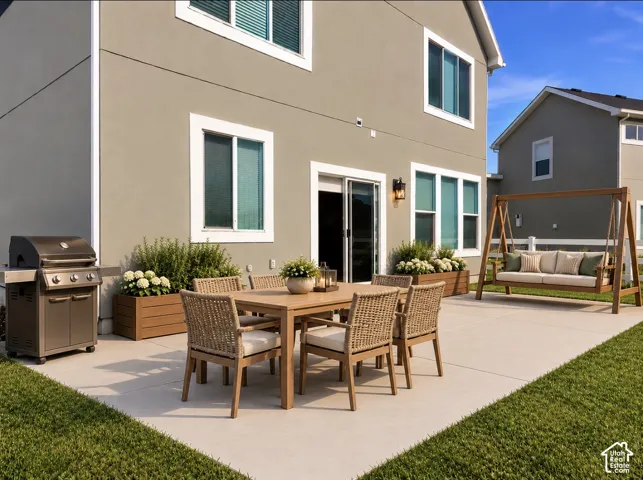 Concrete rear patio featuring built-in wooden planters and an exterior wall-mounted light fixture