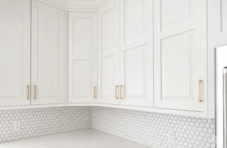 White shaker-style cabinetry with gold-tone hardware