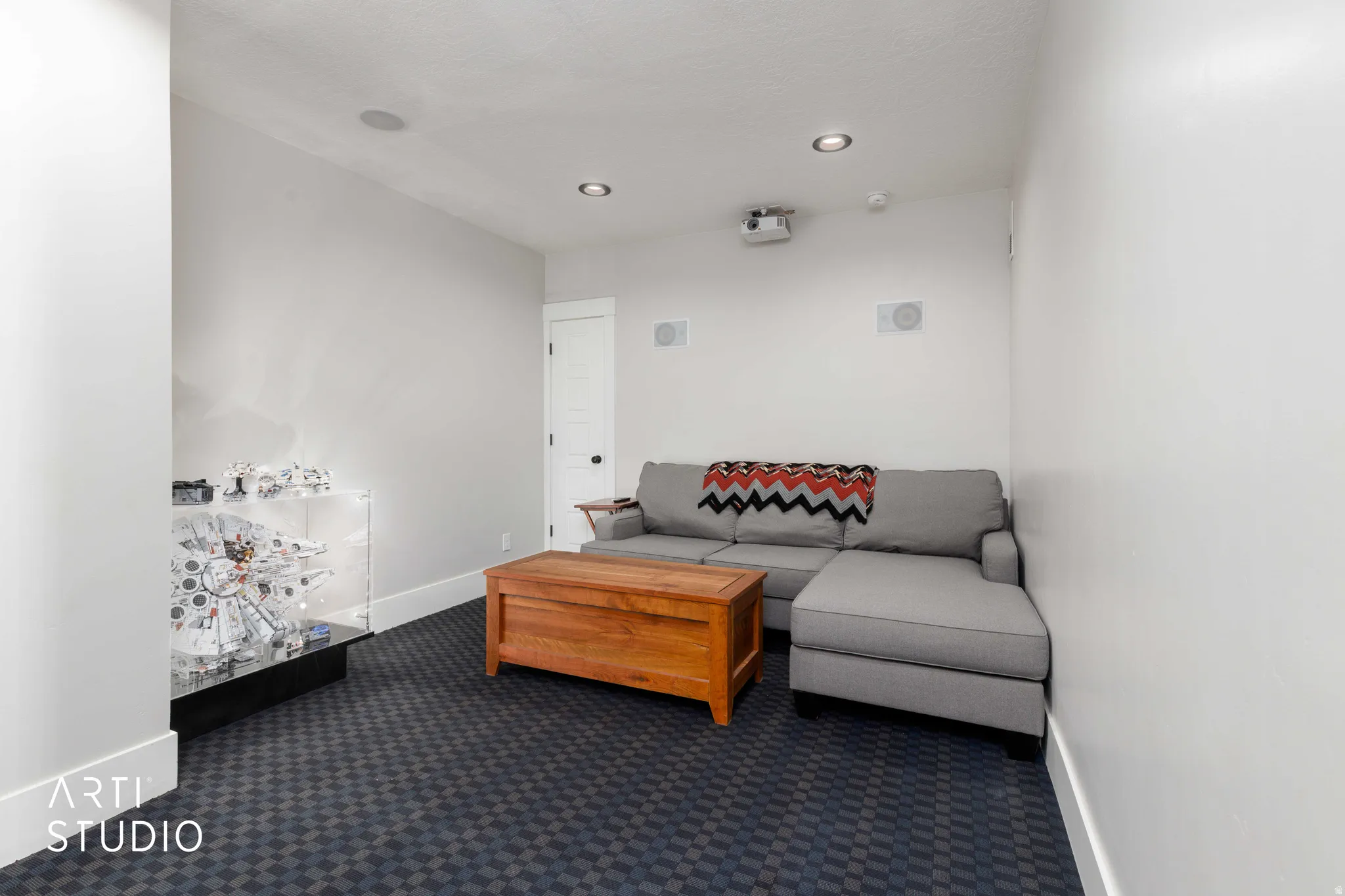 Recessed lighting, built-in ceiling speakers, projector, and patterned carpet flooring