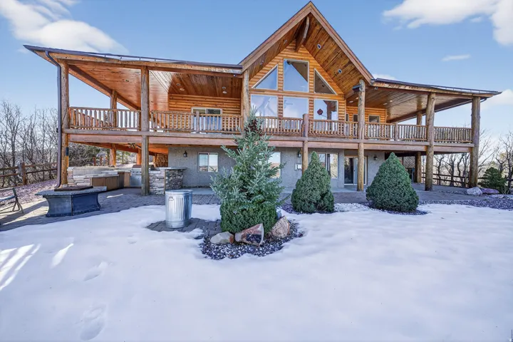 Natural wood-finish log exterior with an expansive wrap-around deck
