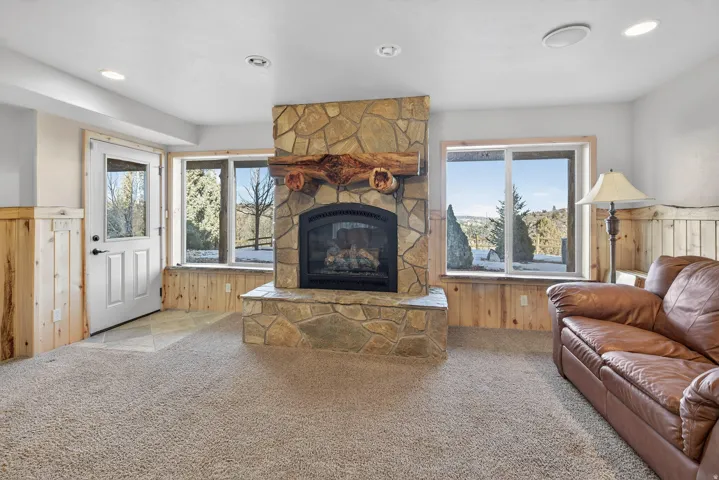 Stone-faced fireplace with a natural wood mantel