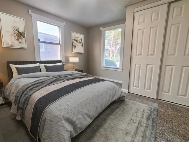 Neutral wall paint, two windows, and paneled sliding closet doors