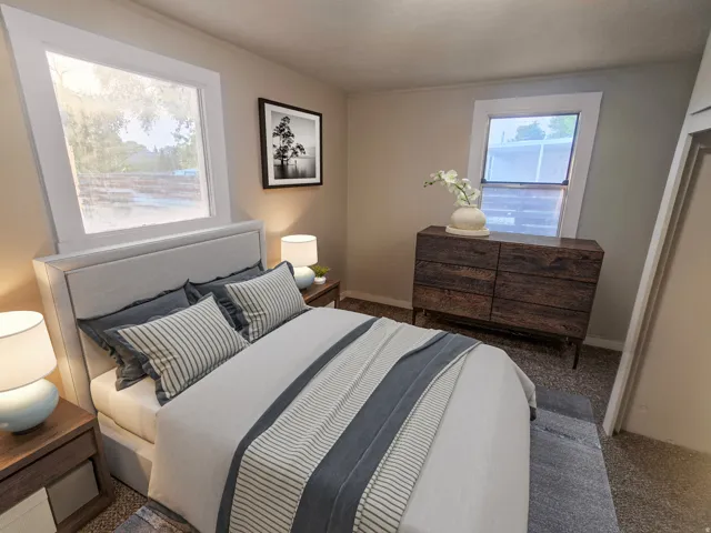 Wall-to-wall carpeting and two windows with white trim