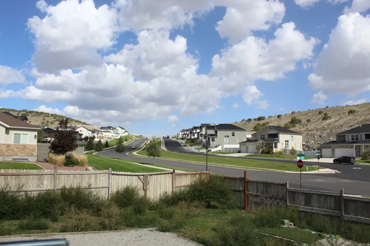 Neighborhood setting with paved streets, manicured green spaces, and contemporary homes