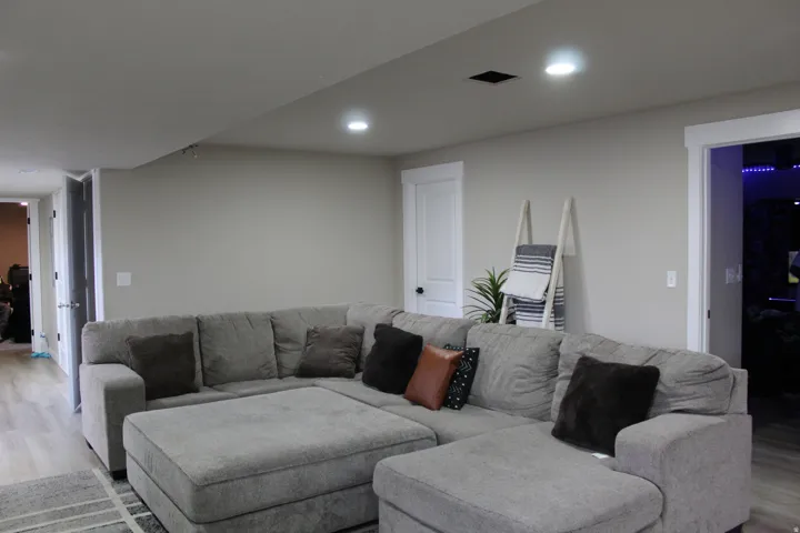 Recessed ceiling lighting, light gray wall paint, white trim, white panel doors, and wood-finish flooring