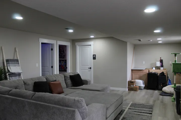 Recessed lighting, light gray wall color, white trim, light wood-finish flooring, and white interior doors