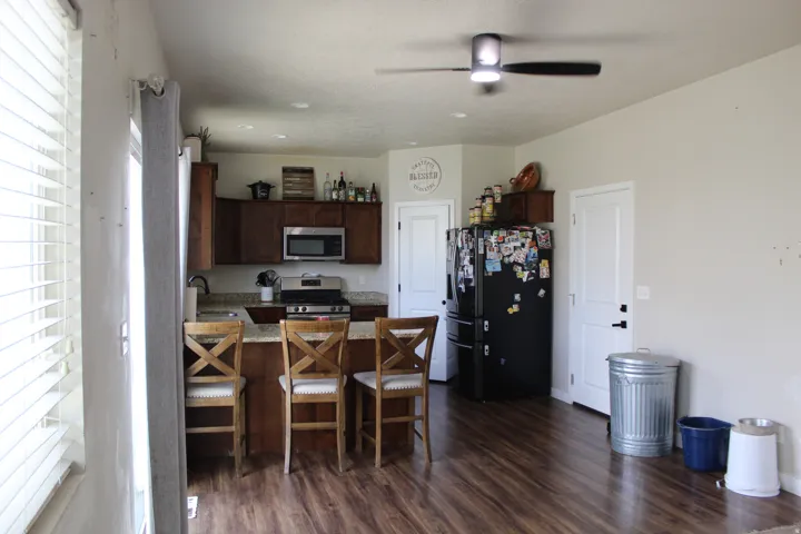 Kitchen with wood-finish flooring, dark wood cabinetry, and stainless steel appliances