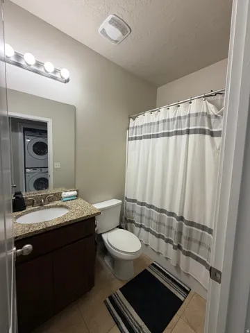 Vanity with a granite-style countertop, a single basin sink, and a dark wood-finish cabinet