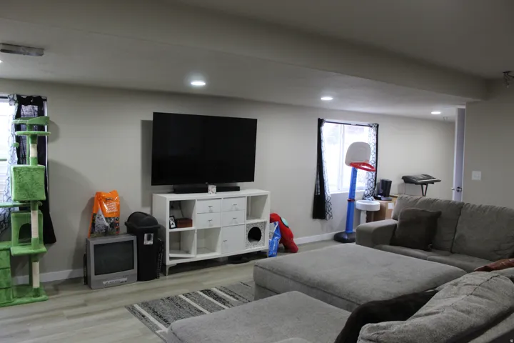 Recessed lighting illuminates the room with wood-finish flooring
