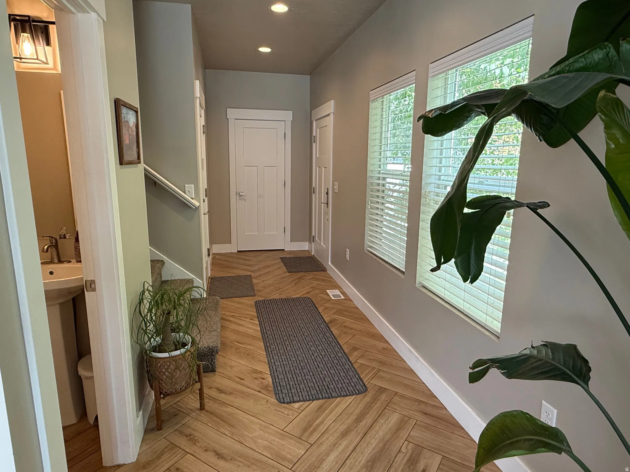 Herringbone wood-finish flooring, recessed lighting, and multiple windows with great natural lighting and blinds